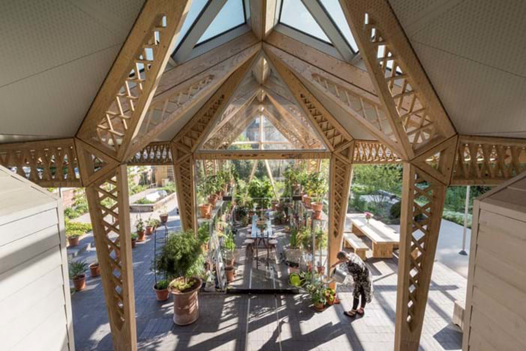The all-glazed greenhouse blends interior with exterior, and acts as both a congenial seating area, workstation and potting shed. © Nigel Young / Foster + Partners
